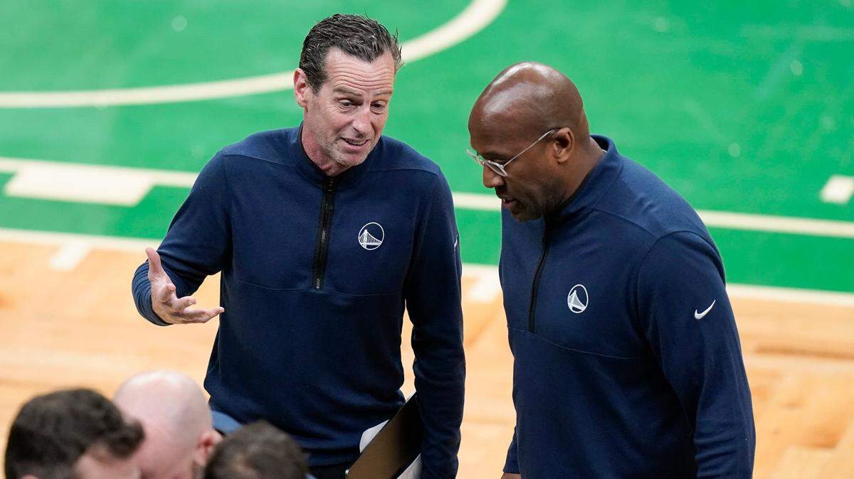 Golden State Warriors assistant coach Kenny Atkinson, left, talks with assistant coach Mike Brown during a timeout during the first quarter of Game 4 of basketball’s NBA Finals against the Boston Celtics Friday in Boston. Atkinson, sources say, will be the Charlotte Hornets’ new head coach.