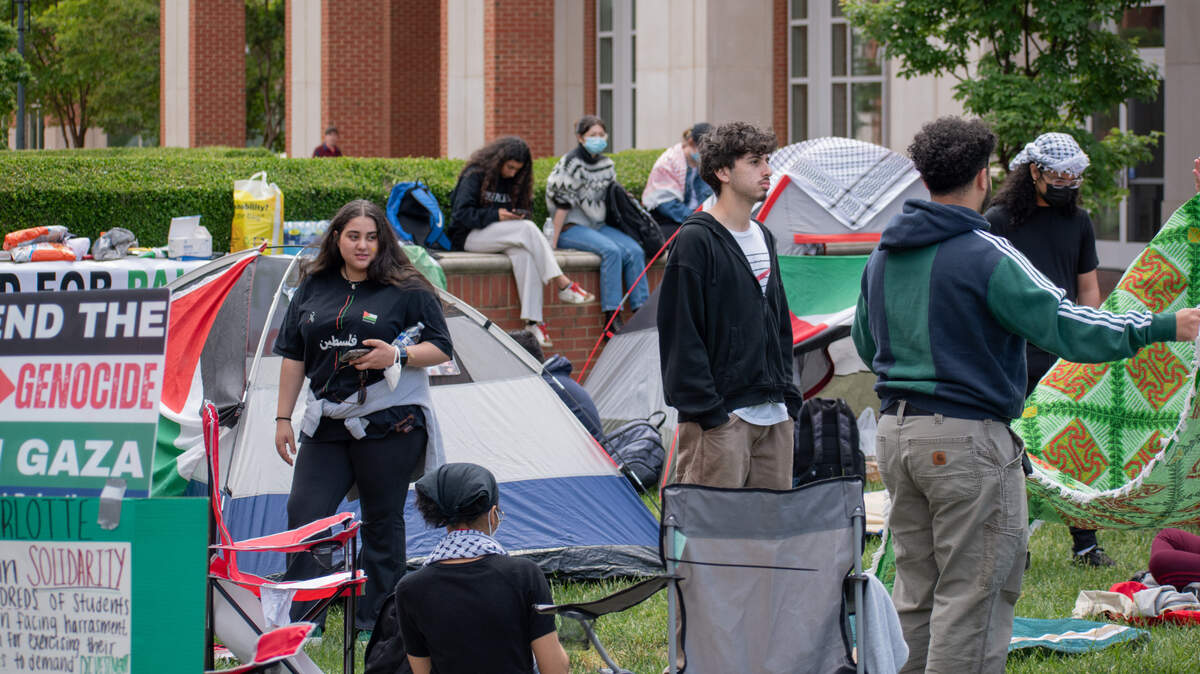 Students set up a small encampment with tents on UNC Charlotte’s campus this week. The school later told the students they needed to remove the tents, but the group continues to gather with blankets on campus.