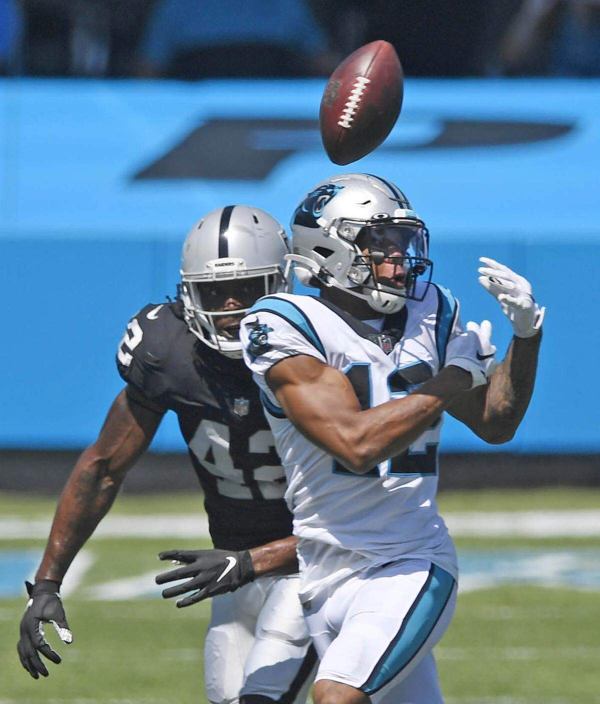 Carolina Panthers wide receiver D.J. Moore (12) loose control of a pass as Las Vegas Raiders inside linebacker Cory Littleton (42) closes in during the first half in their opening game of the 2020 NFL season at Bank of America Stadium on Sunday, September 13, 2020.