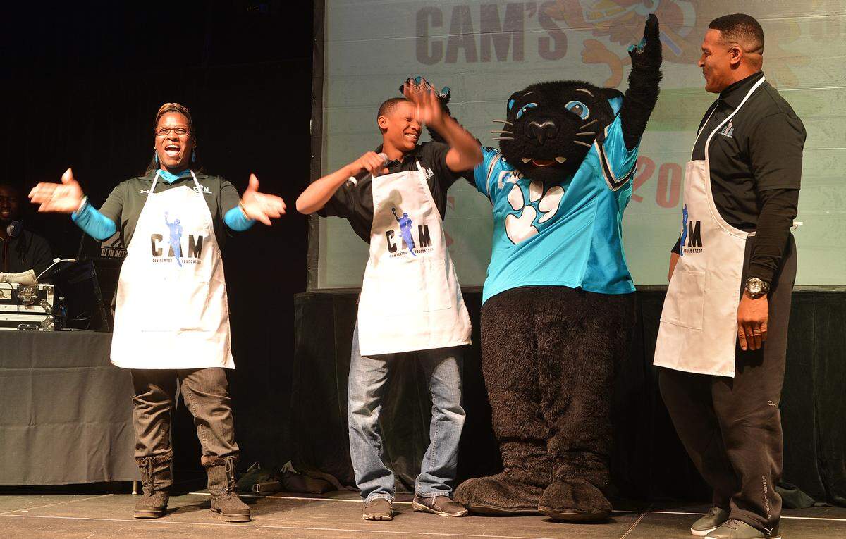 Cam Newton’s younger brother Caylin, middle, and father Cecil, right, are both witnesses to Cam’s behind-the-scenes mentorship.