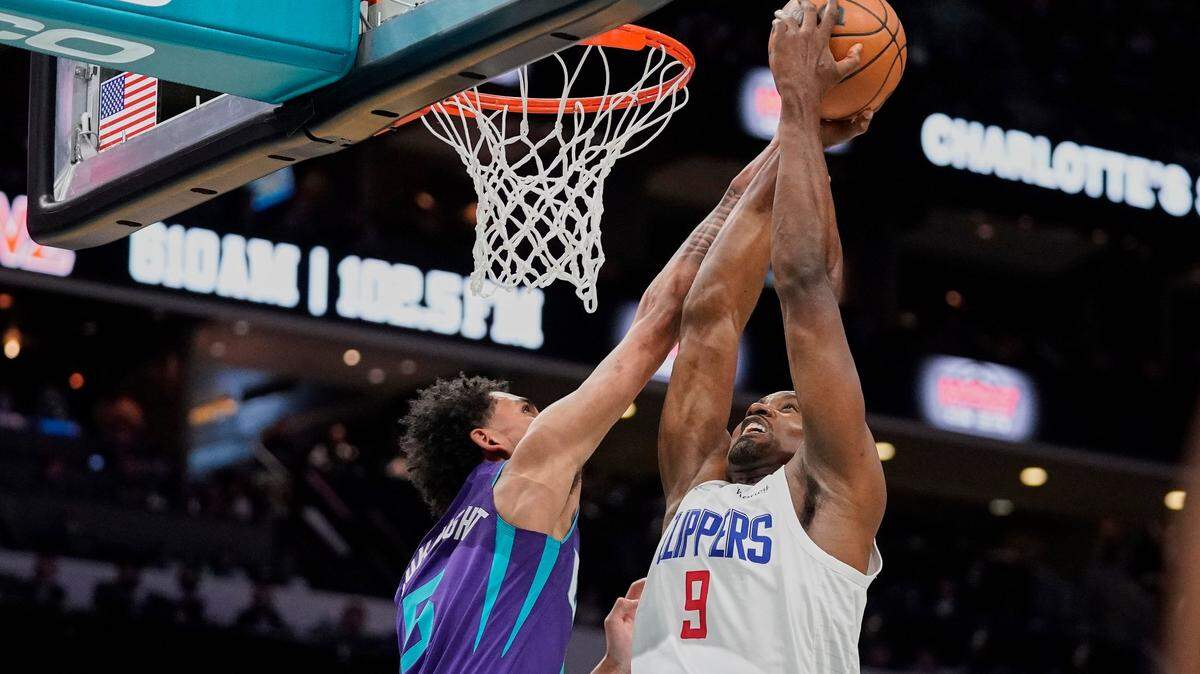 LA Clippers center Serge Ibaka (9) drives towards the basket as Charlotte Hornets guard James Bouknight, left, defends during the first half of an NBA basketball game Sunday, Jan. 30, 2022, in Charlotte, N.C. (AP Photo/Rusty Jones)