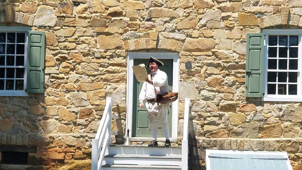 In this file photo, the Meck Dec is read at the Alexander Rock House by a man in period garb.