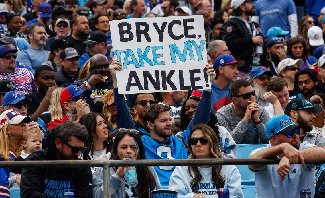 A Panthers fan holds a sign offering his ankle to team quarterback Bryce Young, who sat out this game with an injury, during the game at Bank of America Stadium in Charlotte on Sunday, October 26, 2025.