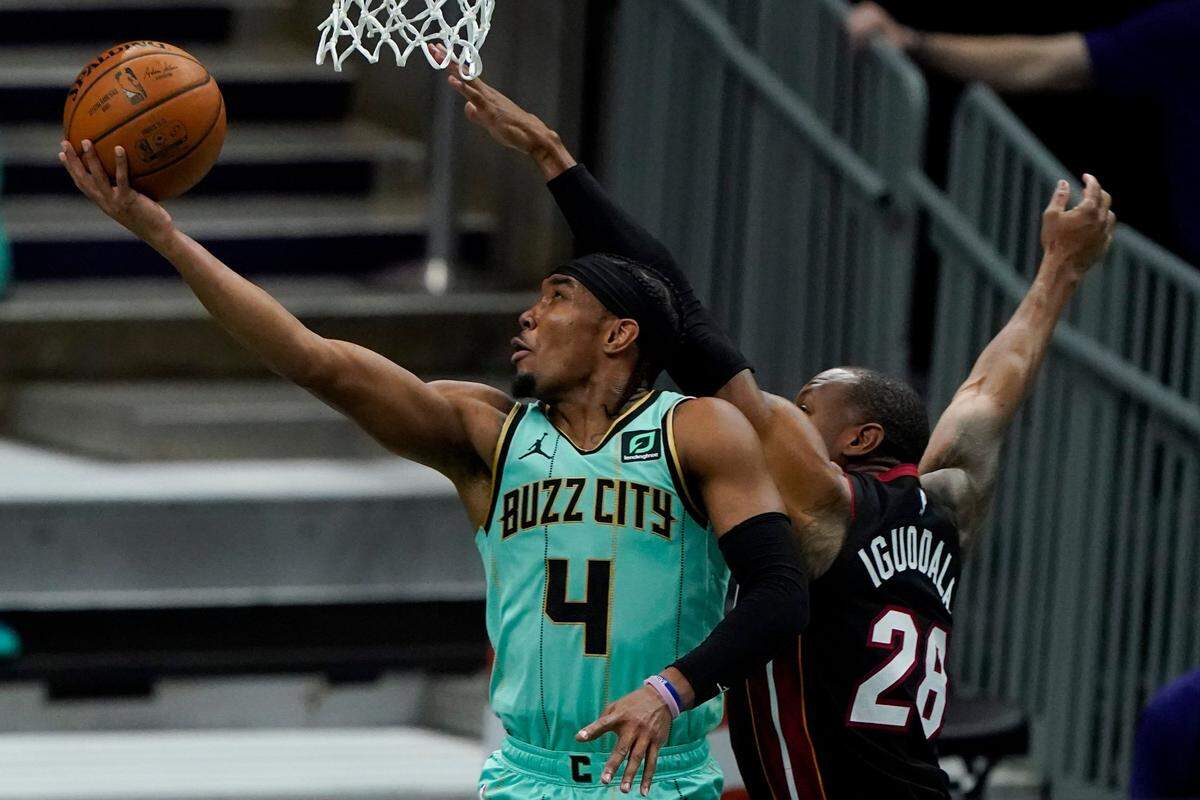 Charlotte Hornets guard Devonte Graham shoots around Miami Heat forward Andre Iguodala Friday. The Hornets are 3-1 since LaMelo Ball broke his right wrist but are about to embark on a six-game road trip.