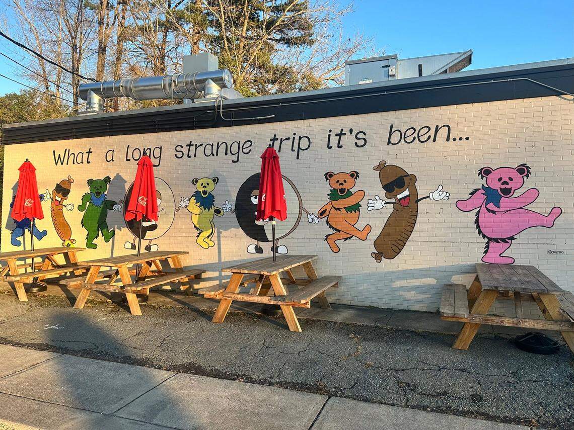 Outside seating at The Good Wurst Company in Plaza Midwood. Its mural is by artist Melissa “Mo” Wineman.