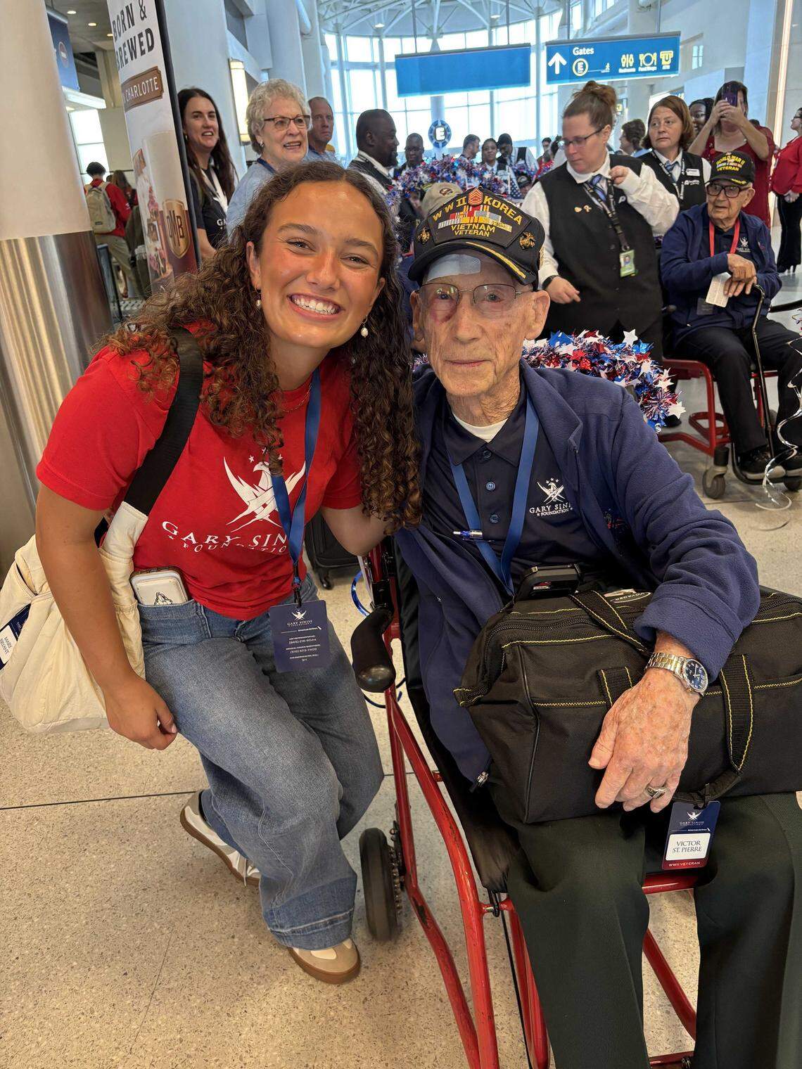 Huntersville student Mary Stanton Bryant escorts Charlotte veteran Vic St. Pierre during a Soaring Valor trip hosted by American Airlines, the Gary Sinise Foundation and the National WWII Museum.