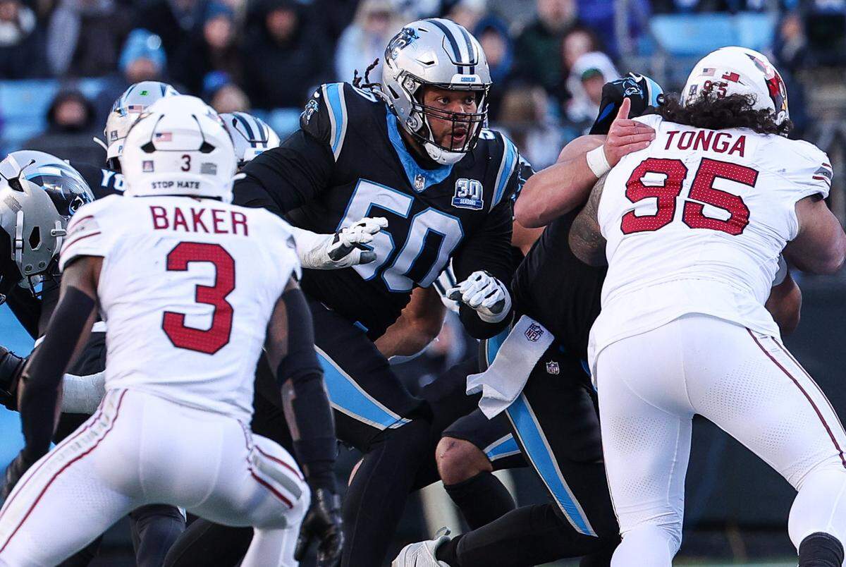 Panthers guard Robert Hunt, center, goes up against the Cardinals defense during the game at Bank of America Stadium in Charlotte, NC on Sunday, December 22, 2024.