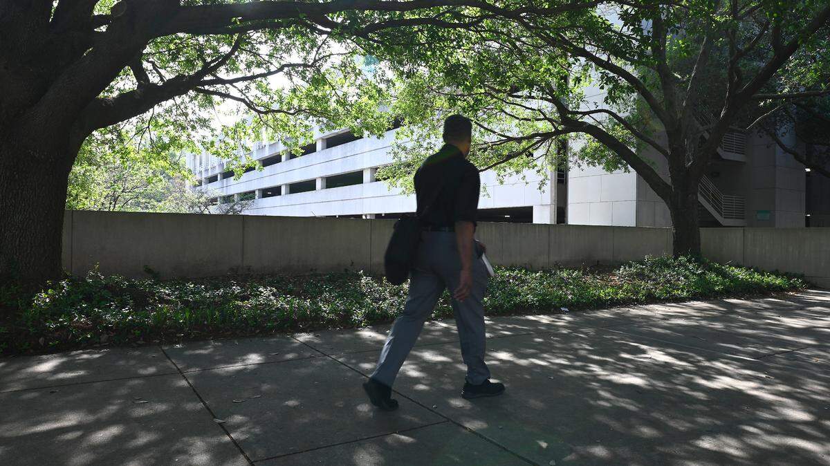 A man walks past the parking deck located near the Charlotte-Mecklenburg Government Center on Tuesday, April 4, 2023. The nonprofit Parking Reform Network published a map last month showing how much land in the top 50 US cities are dedicated to parking i.e. surface lots and parking garages. The study didn’t include on-street parking. This comes as some cities eliminate parking mandates with new development.
