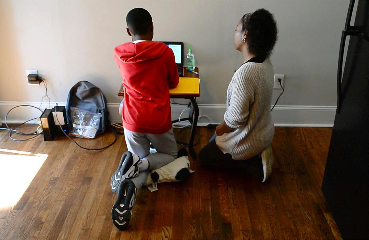 Devonne Moise, right, looks over the computer with her son, Deon’tae, 11, left. Moise is a single mom with five children who is feeling the impact of the COVID-19 virus. Three of the children had jobs that have been temporarily suspended decreasing the families income. Devonne just finished a Goodwill training program and is hoping to get a job with a health care company later this spring. For now, Devonne and her family are struggling to make ends meet.