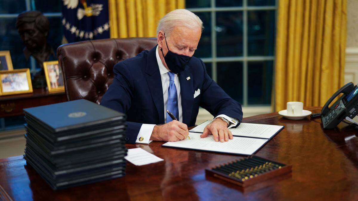 President Joe Biden signs his first executive orders in the Oval Office of the White House in Washington on Wednesday, Jan. 20, 2021. President Biden, vowing to restore environmental protections frayed over the past four years, has ordered the review of more than 100 rules and regulations on air, water, public lands, endangered species and climate change that were weakened or rolled back by his predecessor.