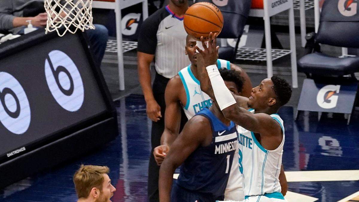 Charlotte Hornets’ Terry Rozier, right, lays the ball up in front of Minnesota Timberwolves’ Anthony Edwards (1) and Jake Layman, left, during the first half of an NBA basketball game Wednesday, March 3, 2021, in Minneapolis. (AP Photo/Jim Mone)
