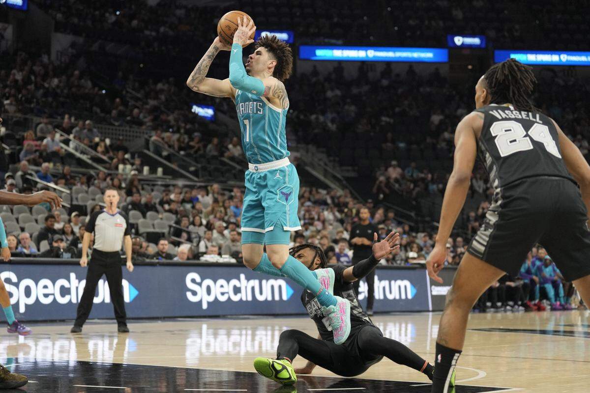 Charlotte Hornets guard LaMelo Ball (1) shoots over San Antonio Spurs guard Stephon Castle (5) during the first half at Frost Bank Center.