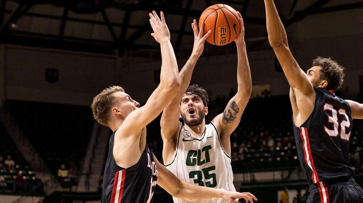 Charlotte’s Luka Vasic (35), center, drives to the basket as Davidson’s David Kristensen (12), left, and Nelson Boachie-Yiadom (32) during a season matchup at the Halton Arena on Tuesday, November 30, 2021.