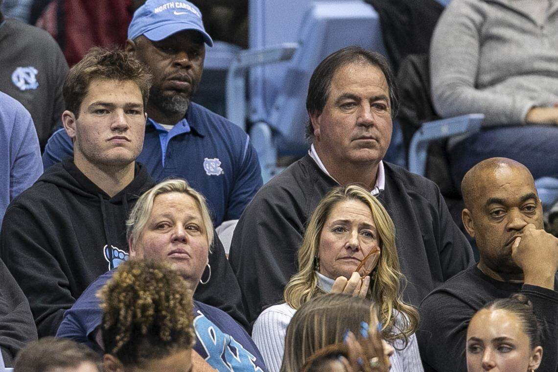 Drake Maye (left) and his father Mark Maye, both former UNC quarterbacks now, watch a Tar Heel basketball game in 2022.