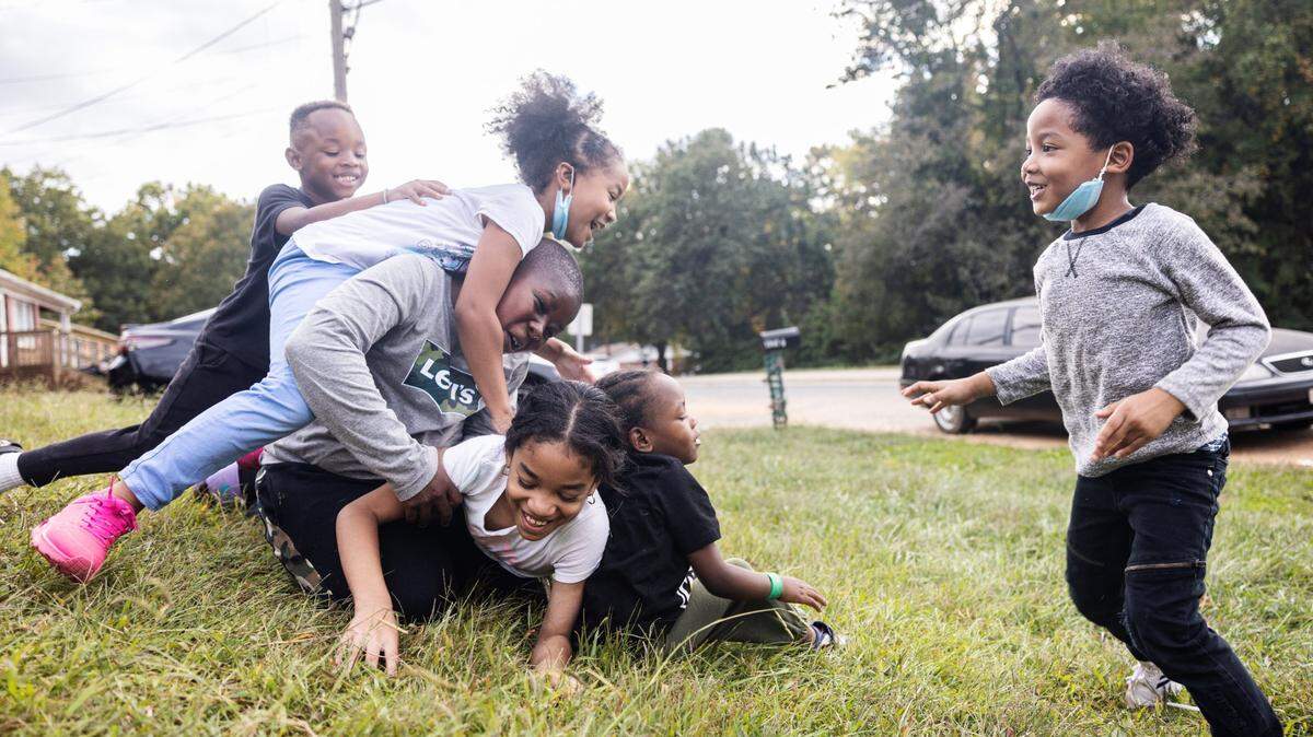 Kids play in a yard in the Smithville neighborhood in Cornelius, N.C., on Tuesday, October 11, 2022. The Smithville Community Coalition aims to fix lingering problems due to a lack of investment and breathe new life into the aging Black neighborhood.