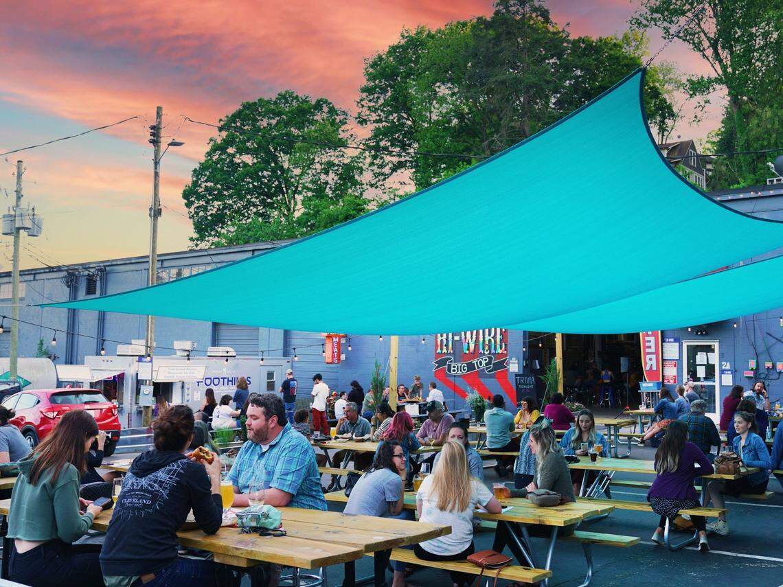 Customers sit on the patio at Hi-Wire’s Biltmore Village location.