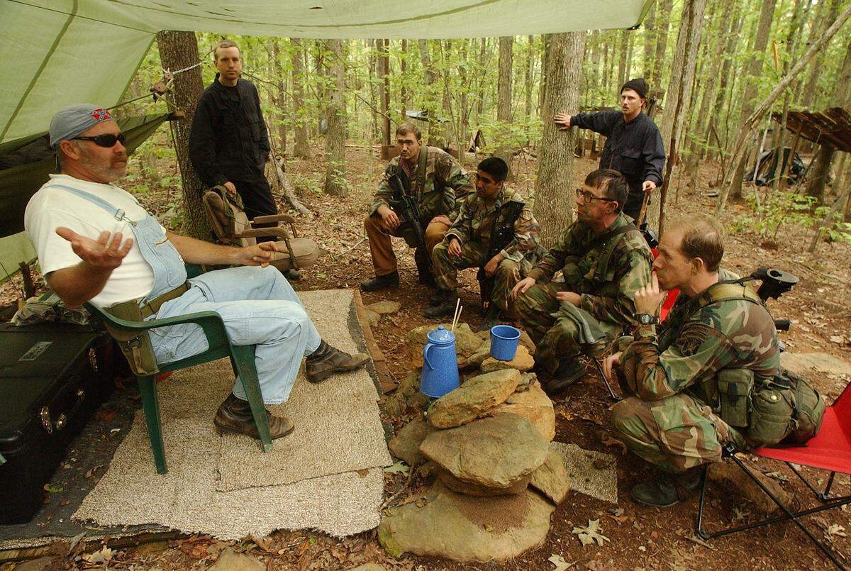 In this 2002 file photo, Philip Young, left, the chief of the guerrilla camp, negotiates with U.S. Army Capt. Arthur Garfer, right, and a Special Forces training group at his camp in the Uwharrie Forest. The Robin Sage training exercise has taken place in the Tar Heel state for over 40 years and involves not only Army Special Forces but civilians and hundreds of volunteers. This summer’s exercise will occur in 19 counties Aug. 1-17.