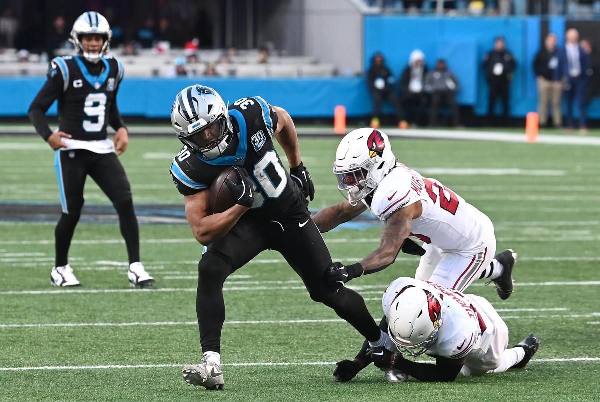 Carolina Panthers running back Chuba Hubbard breaks free of two Arizona Cardinals defenders on the game winning touchdown run in overtime at Bank of America Stadium in Charlotte, NC on Sunday, December 22, 2024. The Panthers defeated the Cardinals in overtime 36-30.
