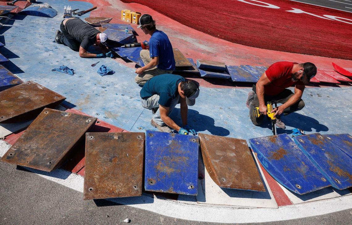 Men work on new anchors for the placement of raised kerbs on the course for the upcoming Roval 400 this weekend at Charlotte Motor Speedway on Tuesdday, Oct. 8, 2024.