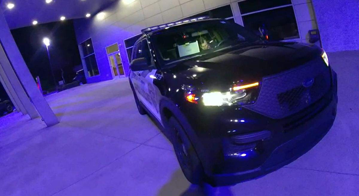 In this image of video provided to WSOC, Brandon Combs can be seen inside a police SUV at a Nissan dealership in Concord moments before now-former Officer Timothy Larson shot and killed him on Feb. 13, 2022.