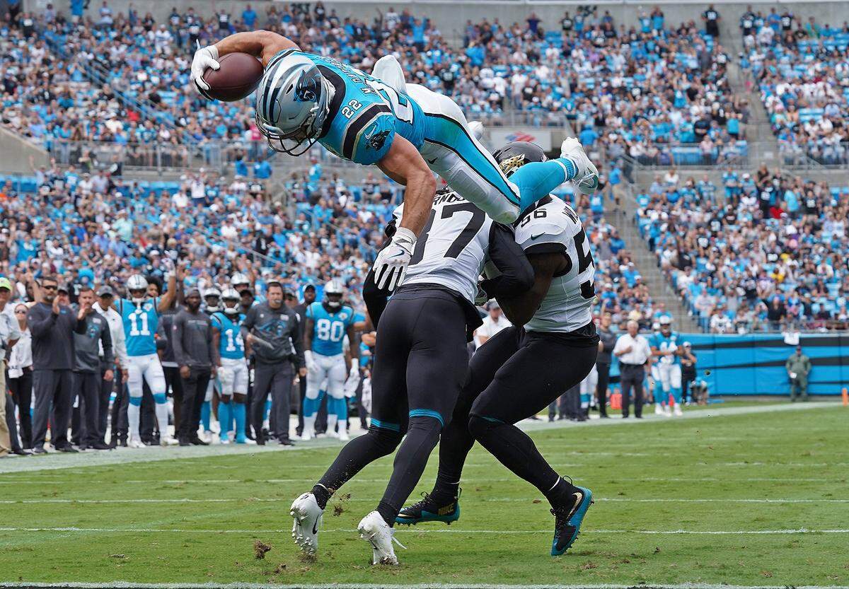 Carolina Panthers running back Christian McCaffrey flies through the air after leaping over Jacksonville Jaguars cornerback Tre Herndon, left as linebacker Quincy Williams looks to assist during first quarter action at Bank of America Stadium in Charlotte, NC on Sunday, October 6, 2019. McCaffrey scored a touchdown on the play.