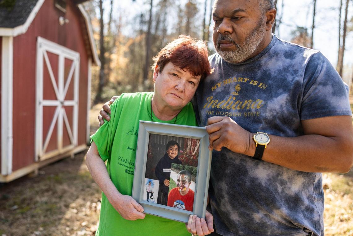 Regina Quick, left and Glenn Ramsey hold a picture frame with photos of Erik Ramsey, Glenn’s son and Regina’s stepson. Ramsey committed suicide in a state prison last year. He was in isolation and had a history of mental health issues.