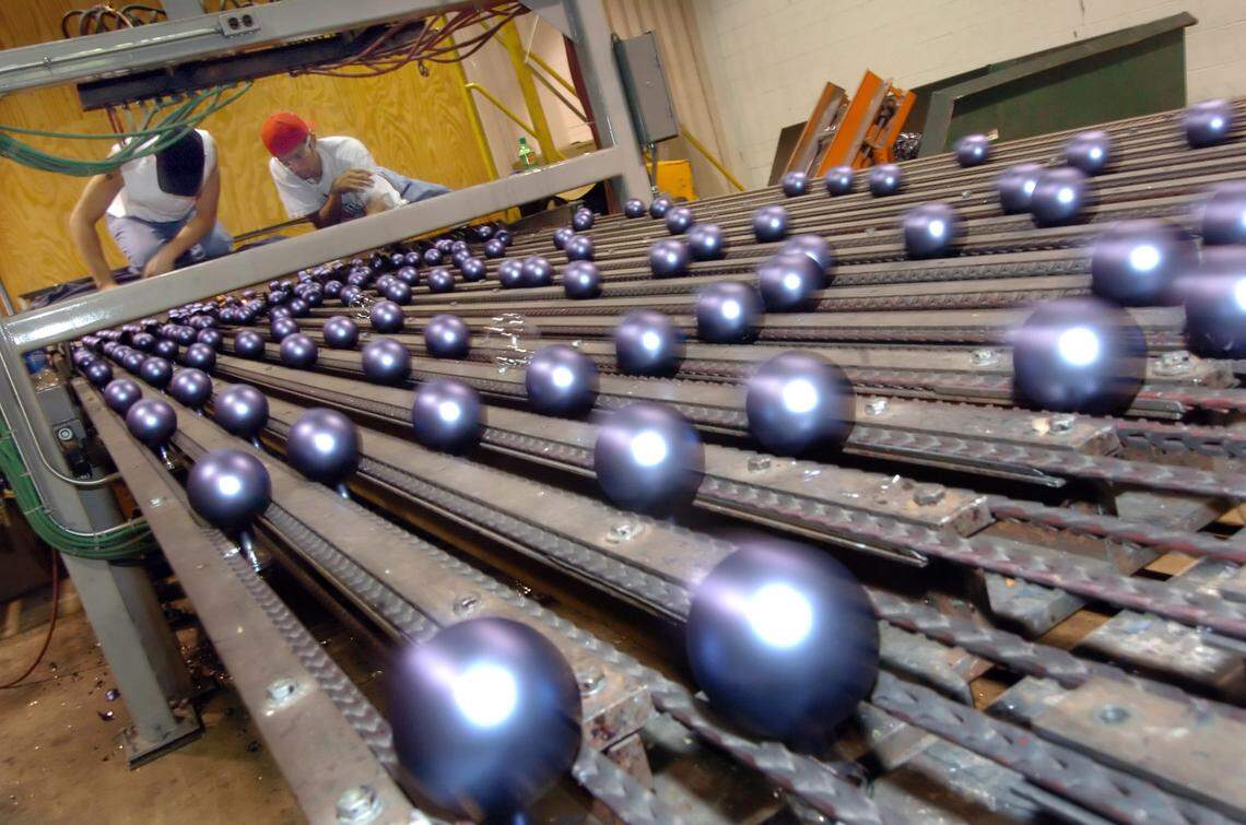 Rauch Industries workers Jason Biddix, left, and Jose Rivera sort Christmas balls on the assembly line at the Gastonia plant in this 2005 file photo.