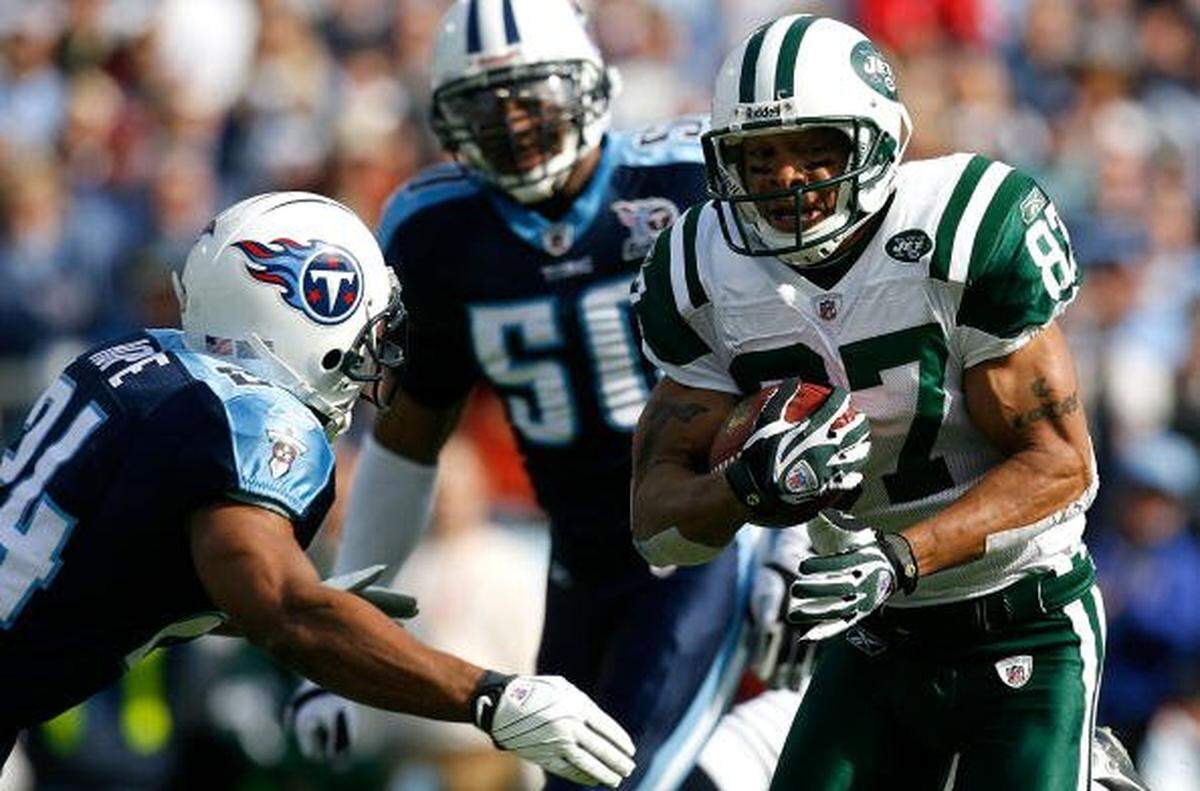 Receiver Laveranues Coles #87 of the New York Jets looks to avoid a tackle by Chris Hope #24 of the Tennessee Titans during the game at LP Field on November 23, 2008 in Nashville, Tennessee.