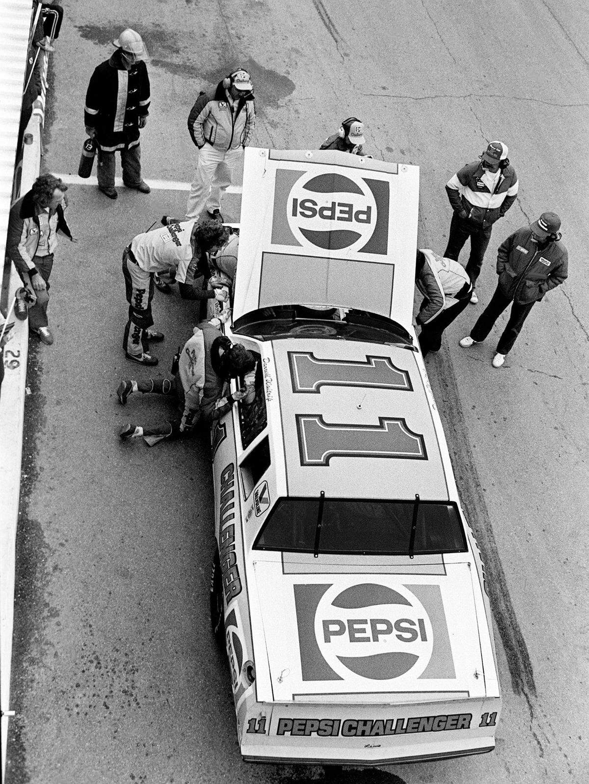 The crew of Darrell Waltrip works on a faltering ignition on pit row during the UNO 125-mile qualifying race for the 25th annual Daytona 500 at Daytona Beach Feb. 17, 1983. Waltrip was running a strong third in the first race before the problems force him into the pit and he finished 20th.