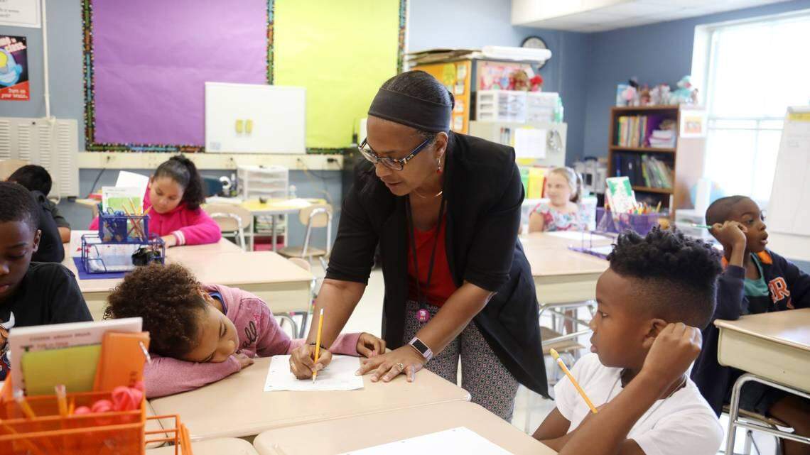 Third graders Ana Toller, left, and D’Ki Watson, right, get help on a math problem from their teacher Yvonne Gayton, center, at Fox Road Elementary School in North Raleigh in September 2019.