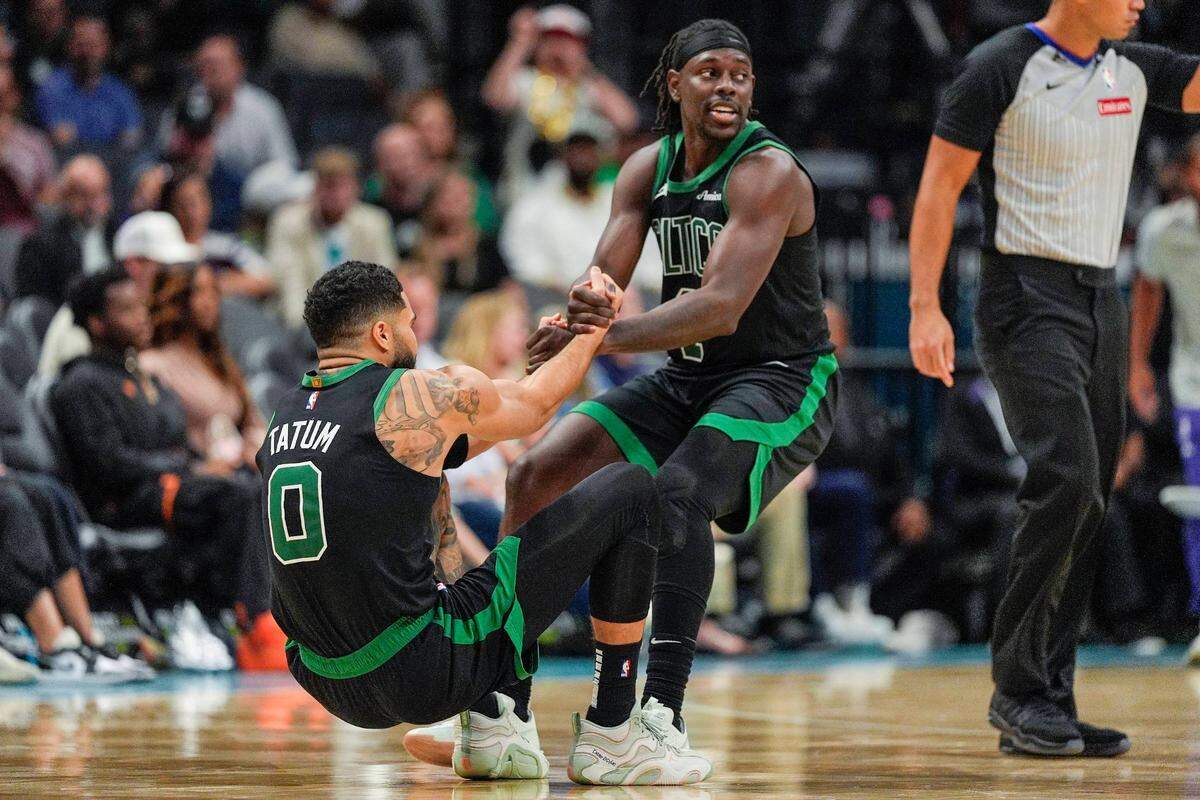 Nov 1, 2024; Charlotte, North Carolina, USA; Boston Celtics guard Jrue Holiday (4) helps forward Jayson Tatum (0) onto his feet after a foul late during the second half against the Charlotte Hornets at the Spectrum Center. Mandatory Credit: Jim Dedmon-Imagn Images