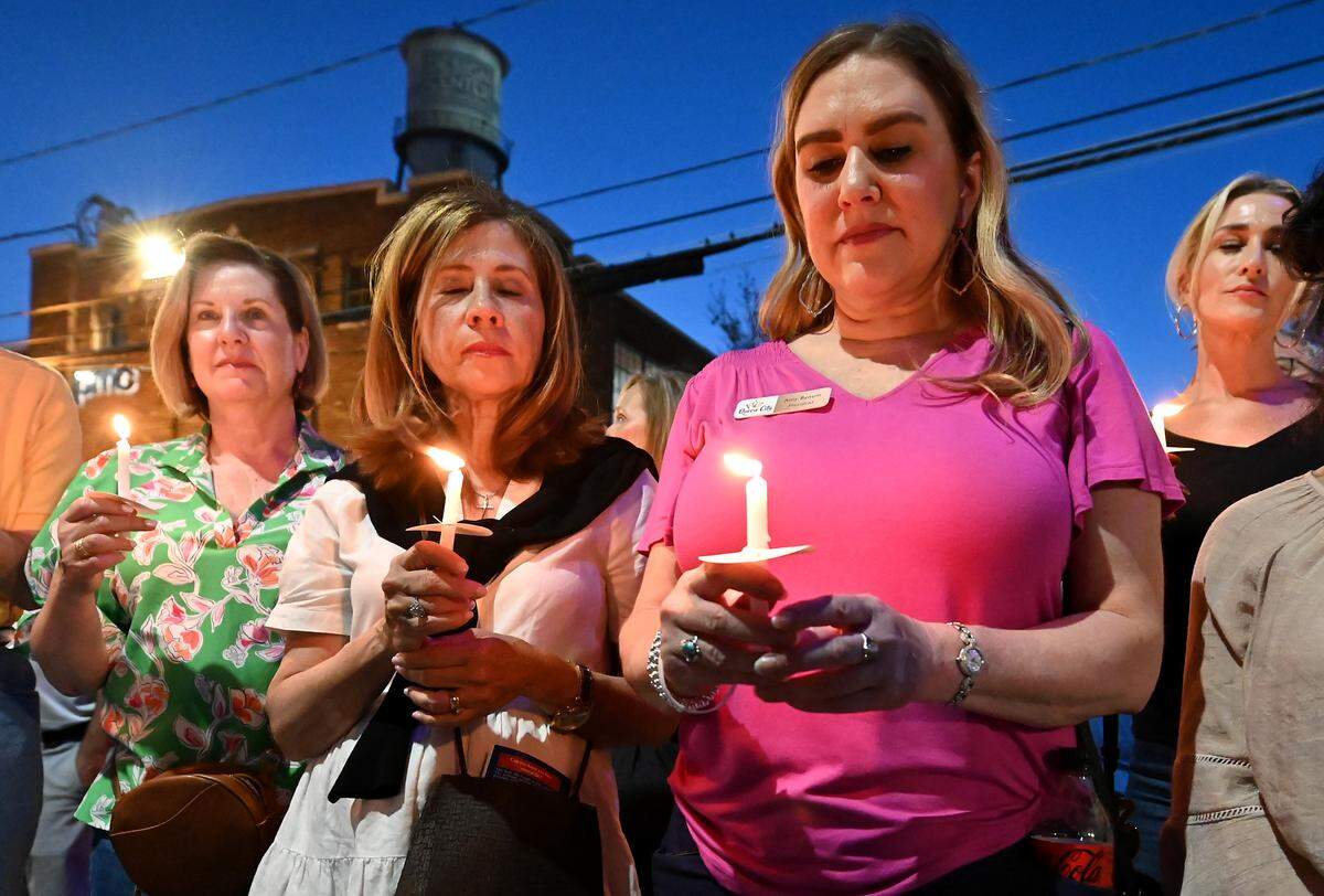 Eva Massi, left, Maria Elena Conaway, center, and Amy Bynum attend a memorial service for Iryna Zarutska on Monday in Charlotte.