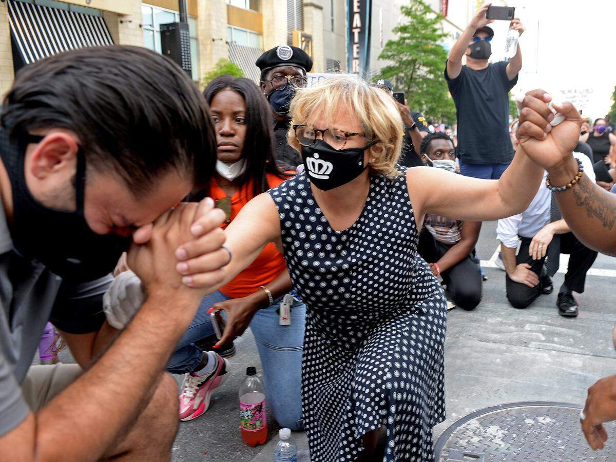 Charlotte Mayor Vi Lyles, center reaches out to comfort city councilman Tariq Bokhari as he sobs at the intersection of 4th Street and College Street in Charlotte, NC on Wednesday, June 3, 2020. The Charlotte City Council and CMPD Chief Kerr Putney attempted to answer questions from demonstrators outside the Charlotte-Mecklenburg Government Center. 
