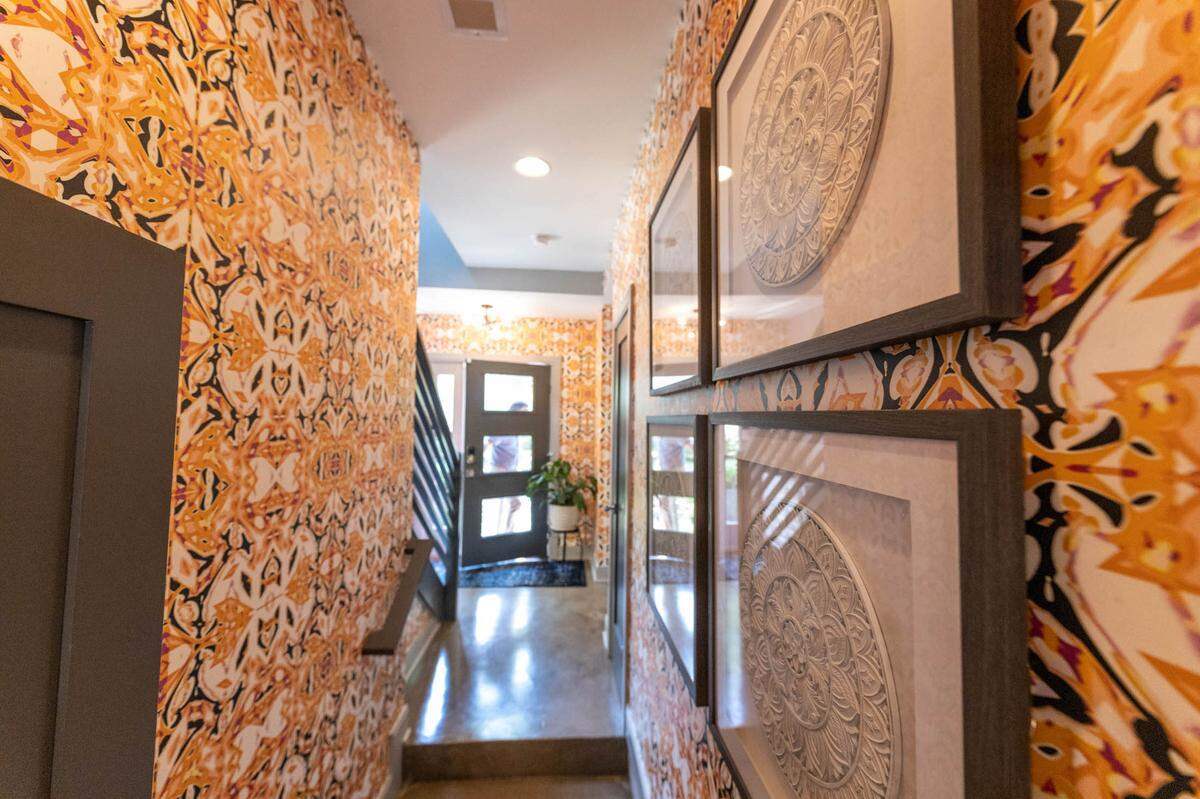 Bright wallpaper decorates the entryway of Rachel and Craig Richards’ NoDa home.