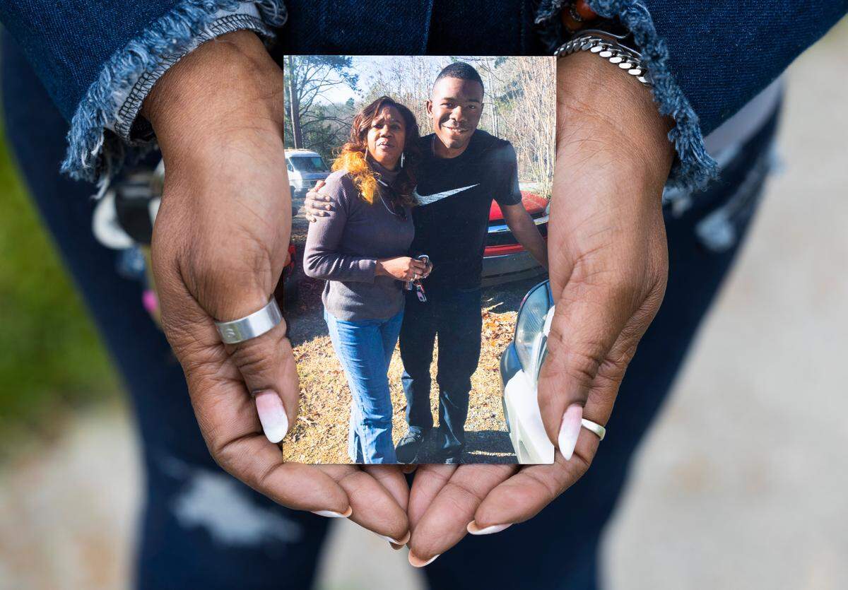 Valerie Smith-Ragland holds a photo of herself and her son, Makari Jamel Smith. Makari was shot to death by sheriff’s deputies in Feb. 2022 while he was suffering a schizophrenic crisis. It took more than a year for the autopsy report to be completed, and that held up insurance payments. “It has put me in massive financial strain,” Smith-Ragland said.