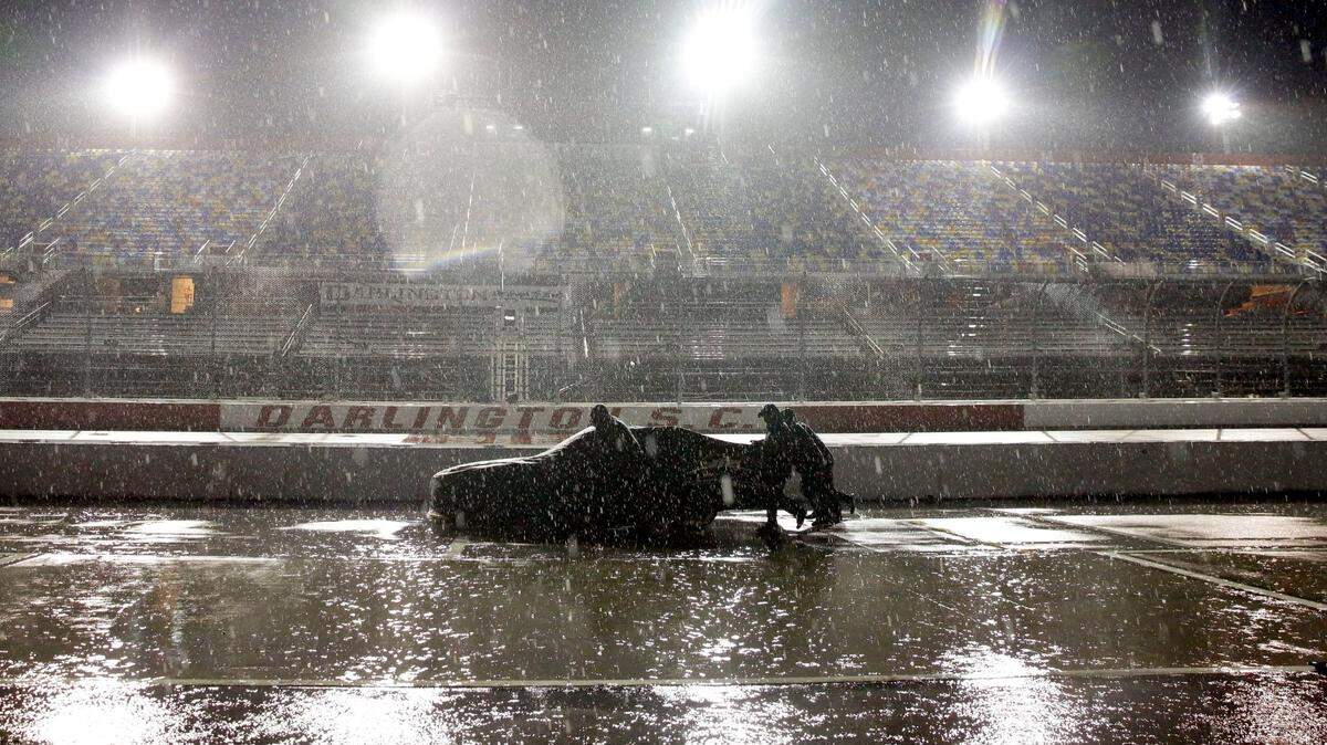 A crew pushes a car through the pit area at Darlington Raceway after the NASCAR Xfinity series auto race was postponed because of rain in May. Stormy weather is in the forecast for Wednesday’s night race at Martinsville.