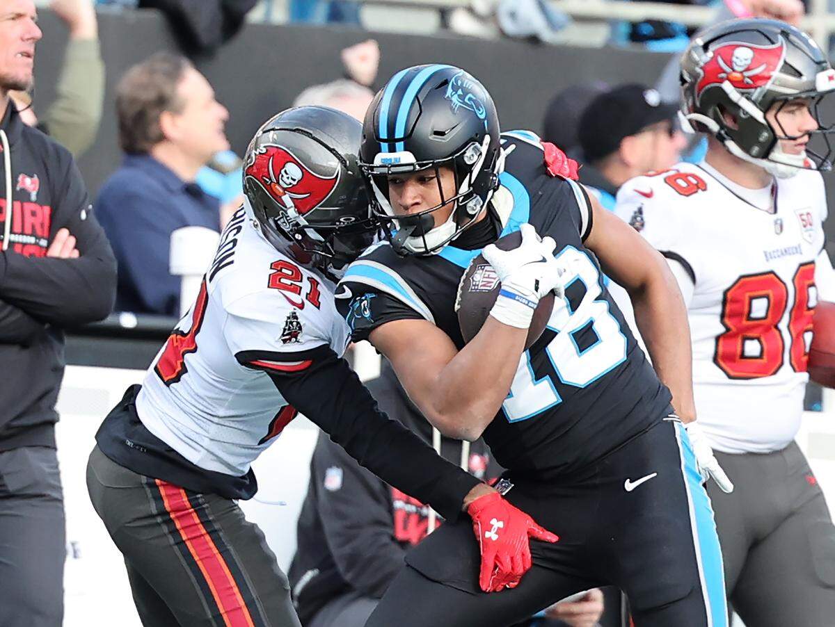 Carolina Panthers Jalen Coker braces for contact as Tampa Bay Buccaneers Benjamin Morrison makes the stop in a Dec. 21, 2025 game at Bank of America Stadium.