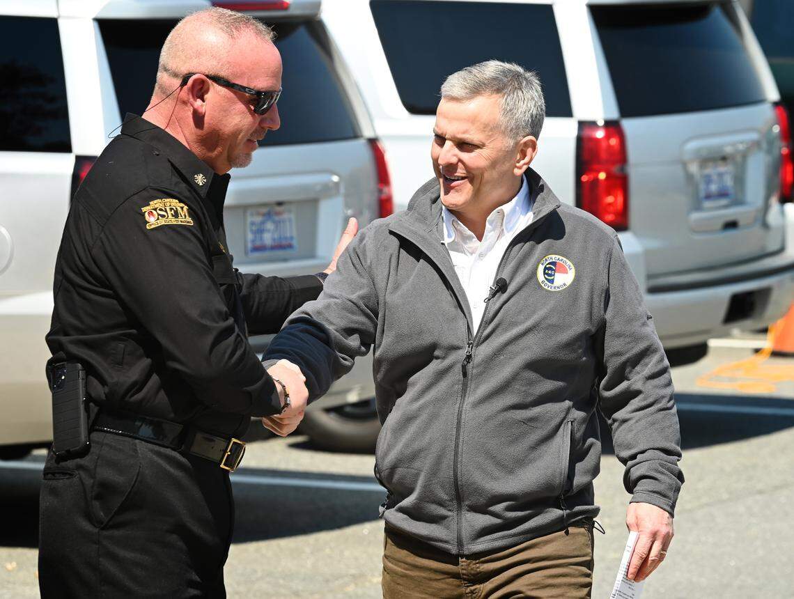 Gov. Josh Stein, right, is welcomed to a briefing about the wildfires in Western North Carolina on Thursday, March 27, 2025. Fires threatening the area have caused some roads to be closed. Stein was briefed by local officials at the Tryon International Equestrian Center & Resort.