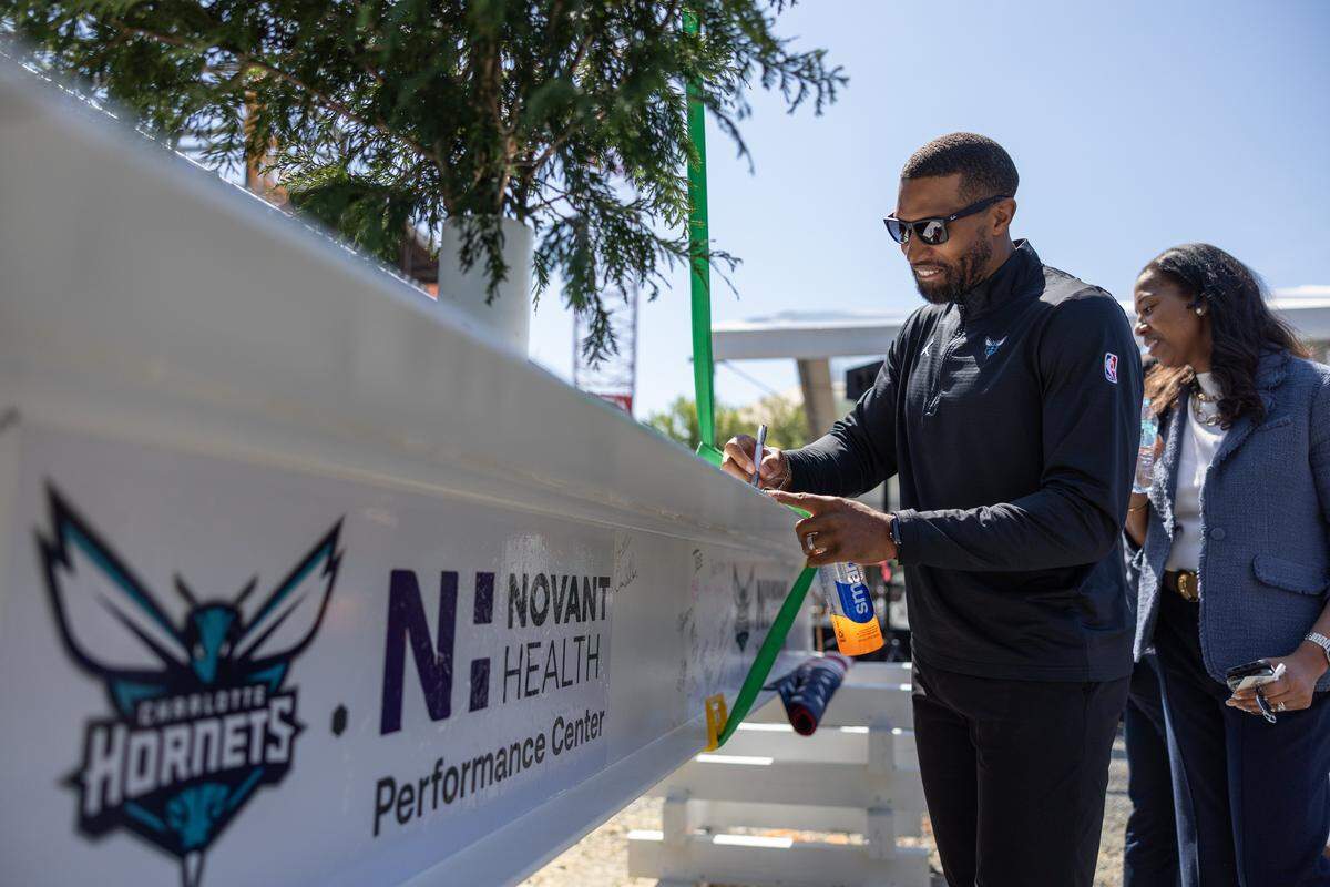 Hornets coach Charles Lee signs the beam during the Hornets' ceremonial Topping Off Ceremony at Novant Health Performance Center's construction site, celebrating a major milestone, the placement of the building's final structural beam in Charlotte, N.C., on Monday, May 4, 2026.