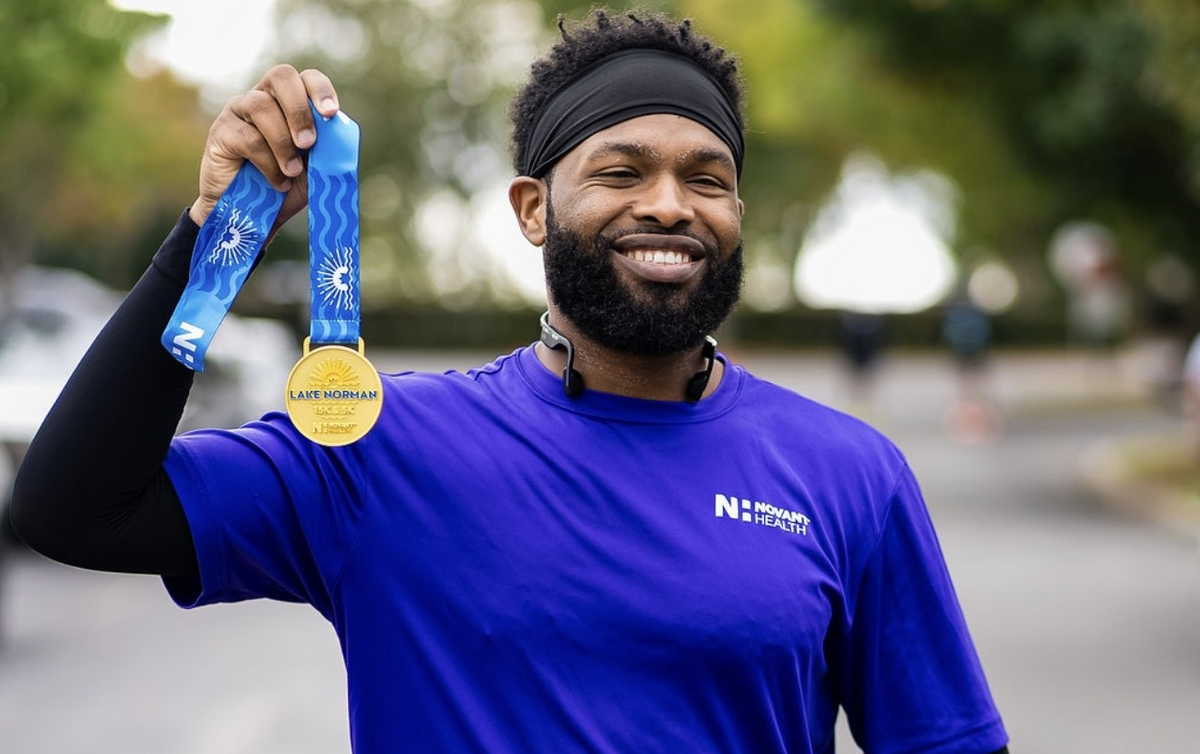 Tevin Price shows off the medal he earned at the Novant Health Lake Norman 15K in Cornelius last month.
