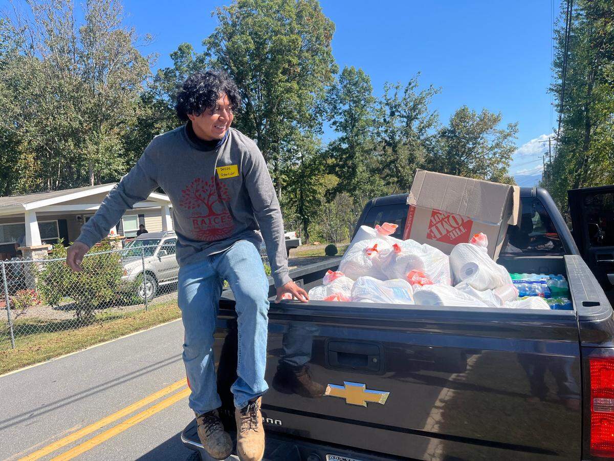 Deydis Macario gets off the back of a pickup truck, ready to hand out supplies to the people in his community. Not long after Helene hit, neighbors like Macario took matters into their own hands in Emma, N.C.