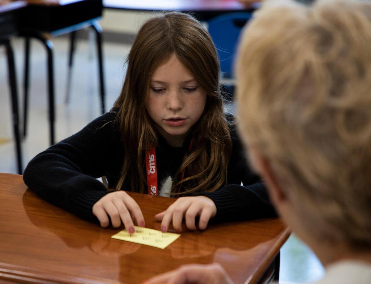 A student at Lansdowne Elementary separates six stars on a card into two groups in a Heart Math tutoring session on Wednesday, Nov. 9, in Charlotte, NC.