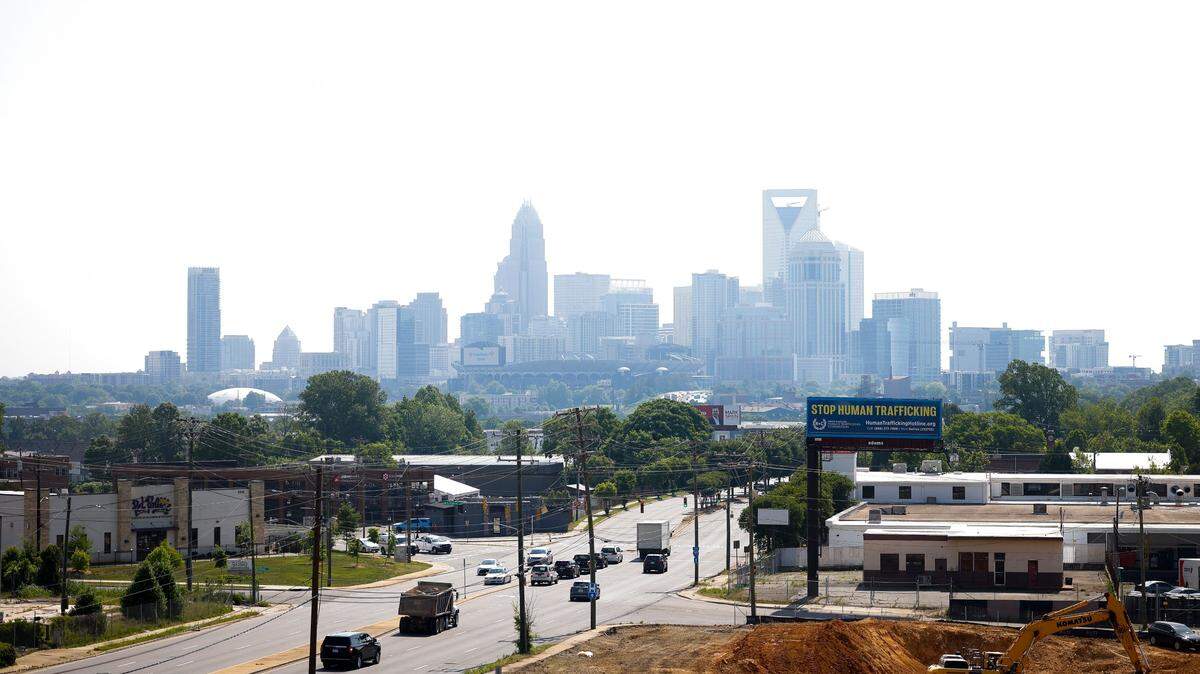 Motorists travel along Wilkinson Boulevard as the Charlotte city skyline is veiled in a layer of haze Thursday, May 19, 2022.