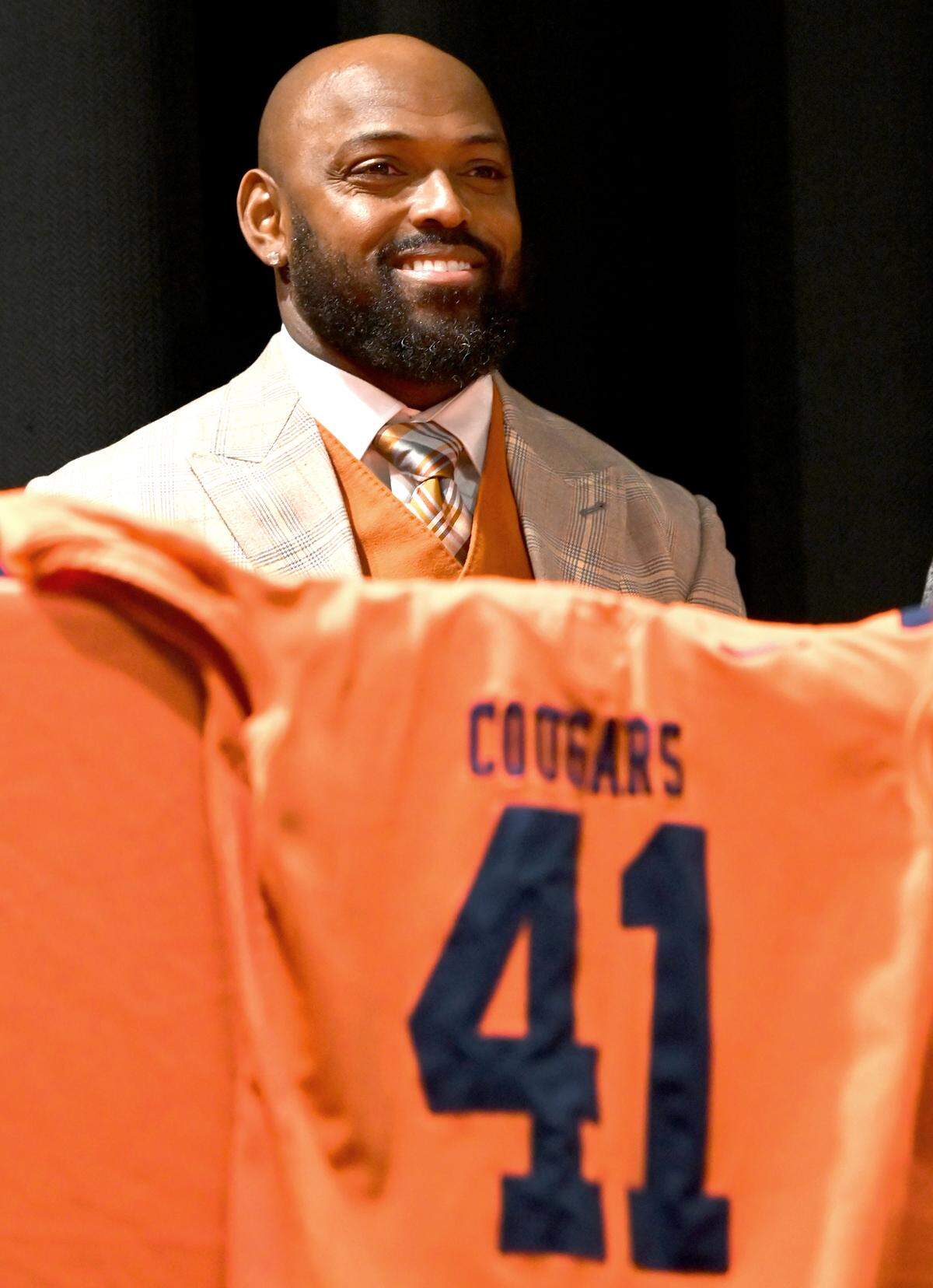 Former Carolina Panthers cornerback Captain Munnerlyn smiles as he is introduced as the new head football coach at Julius Chambers High School in Charlotte, NC on Friday, January 24, 2025. The dais had a Cougars jersey with Munnerlyn’s former Panthers jersey number.