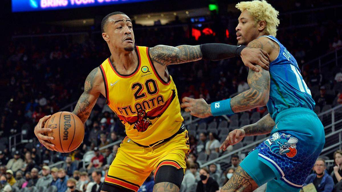 Atlanta Hawks forward John Collins (20) drives past Charlotte Hornets forward Kelly Oubre Jr. during the first half of an NBA basketball game Sunday, Dec 5, 2021, in Atlanta. (AP Photo/Edward M. Pio Roda)