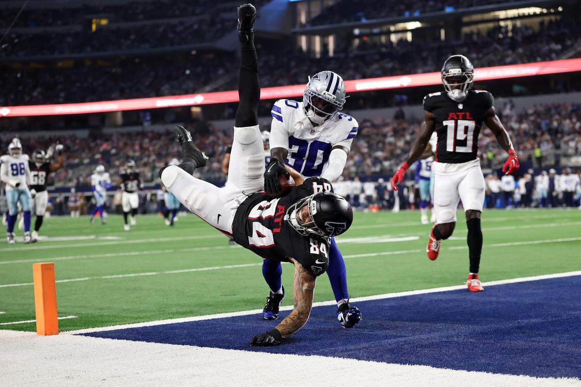 Atlanta Falcons tight end Feleipe Franks scores a touchdown in front of Dallas Cowboys CB Robert Rochell during the second quarter of an NFL Preseason 2025 game at AT&T Stadium on August 22, 2025 in Arlington, Texas.