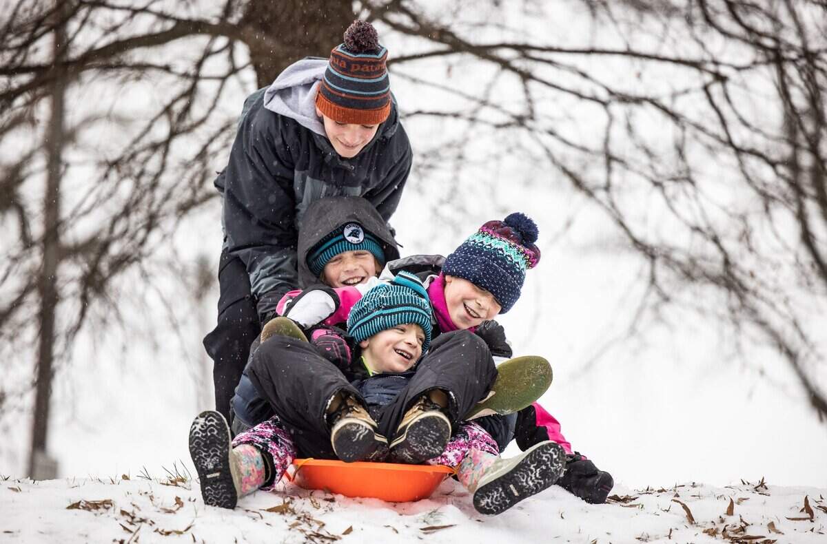 Owen Moore, 13, pushes his siblings on a sled down a hill, back to front, Cormac, 12, Agnes, 10, and Eamon, 8, after snow fell on Charlotte, N.C., on Sunday, Jan. 16, 2022. The photo is part of Observer photojournalist Khadejeh Nikouyeh’s winning N.C. Press Association entry.