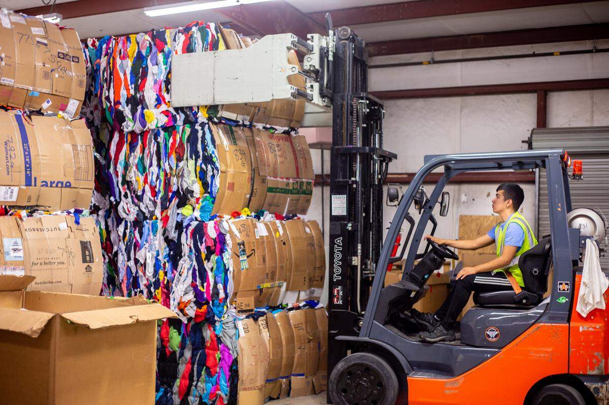 Angel Rojas, a worker for Material Return, pulls one of the clothing bales that is ready for processing in a warehouse in Valdese near Morganton, NC on Thursday, November 21, 2019. The small manufacturer has brought innovative solutions to a traditionally textile industry in their region.