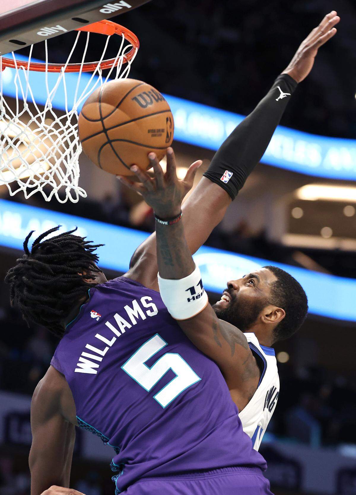 Charlotte Hornets center Mark Williams, left, applies defensive pressure on Dallas Mavericks guard Kyrie Irving Monday. Irving led all scorers with 33 points, but the Hornets won, 110-105.