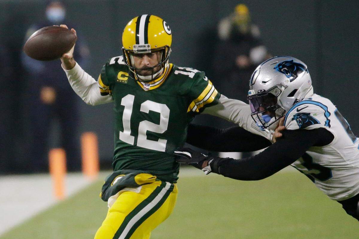 Green Bay Packers’ Aaron Rodgers tries to run past Carolina Panthers’ Brian Burns during the first half of an NFL football game Saturday, Dec. 19, 2020, in Green Bay, Wis. (AP Photo/Mike Roemer)